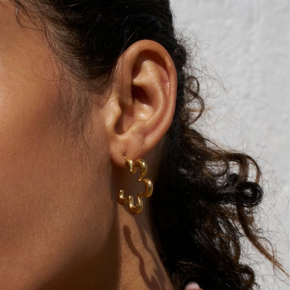 Aretes de aro dorados con flores geométricas