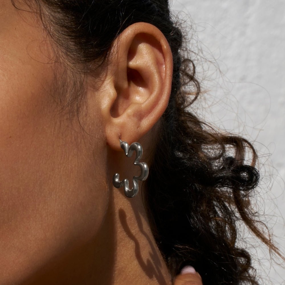 Pendientes de aro geométricos con flores plateadas
